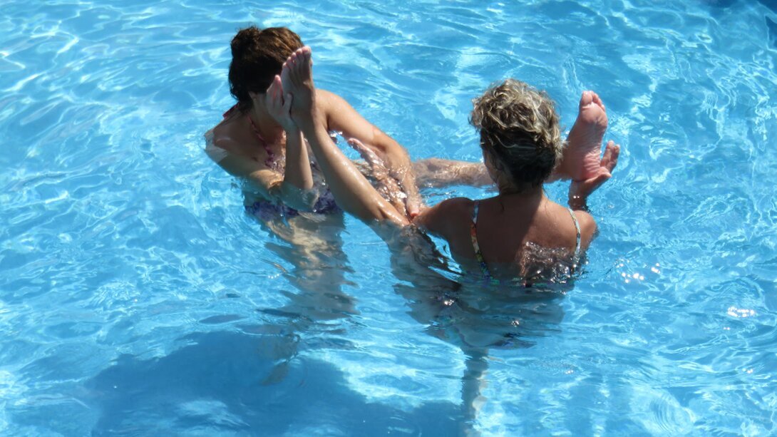 Lezione di WOGA con persone che praticano posizioni di yoga in acqua